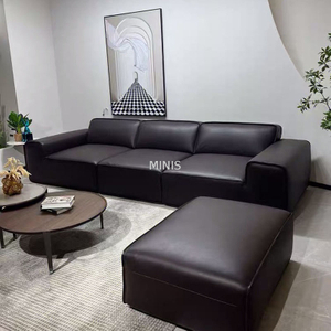 Schönes, bequemes Sofa aus schwarzem Leder im Wohnzimmer mit Ottomane