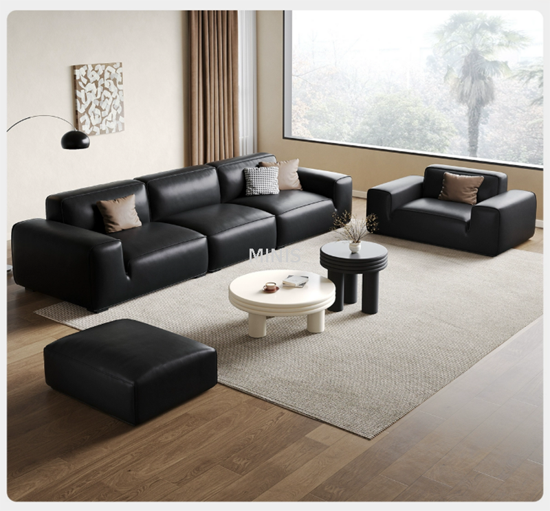 Wohnzimmer, das um ein modernes schwarzes Sofa herum gestaltet ist